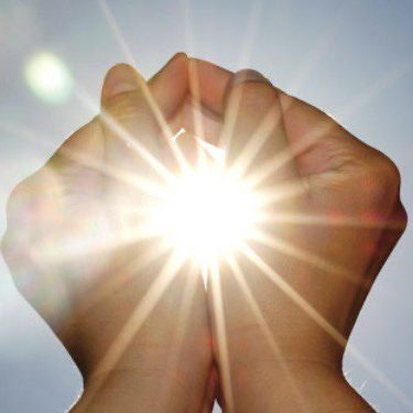 Symbolbild für Energiearbeit – Hände bündeln Licht in der Sonne